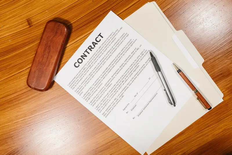 Company contract papers with a pen on a wooden desk