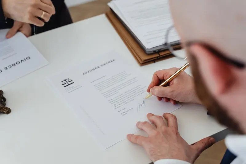 Man signing a legal document at a desk