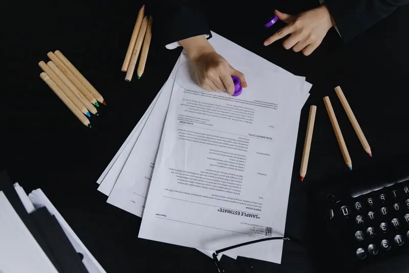 Printed documents being checked and marked at a desk