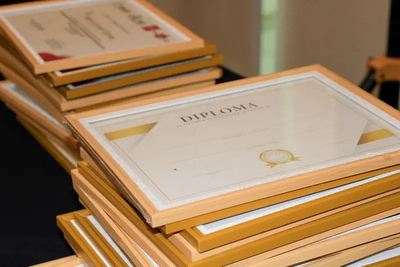 Stack of framed diplomas and certificates